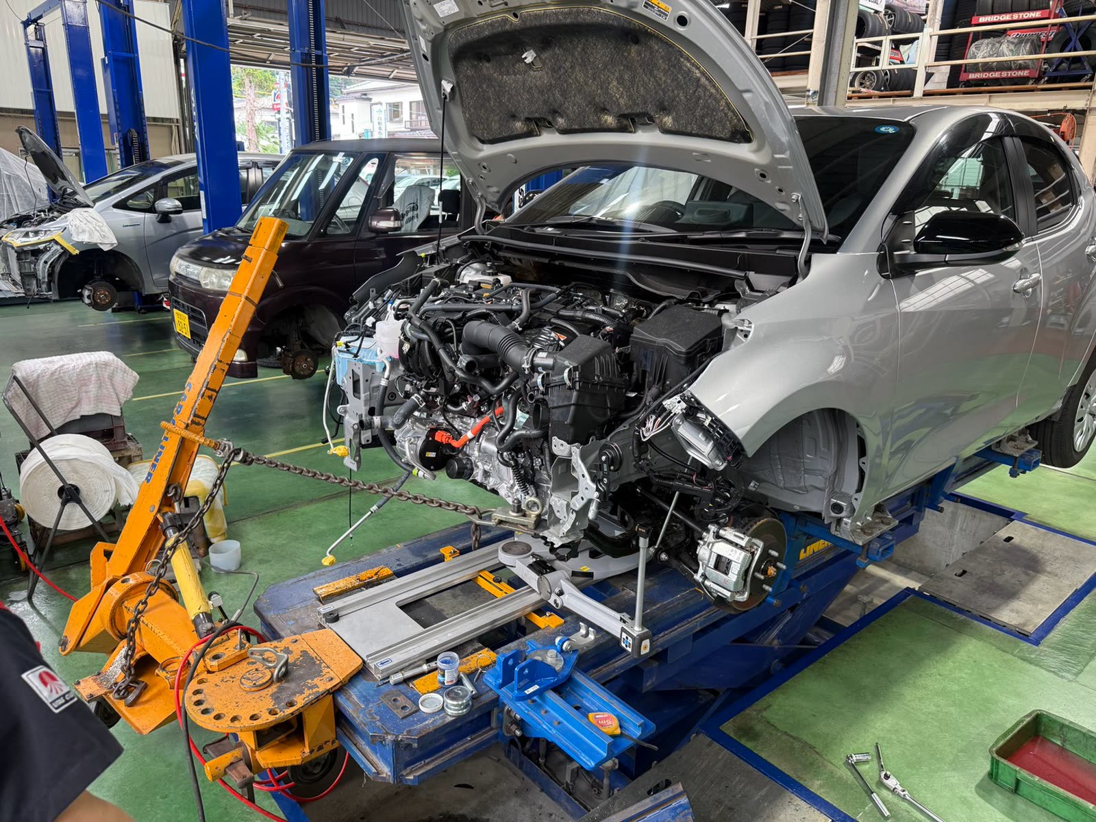 フレーム修正機（ベンチ）で車体を引き出す作業